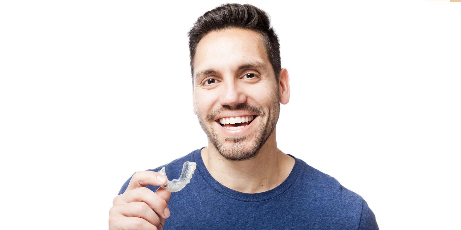 man holding clear aligners